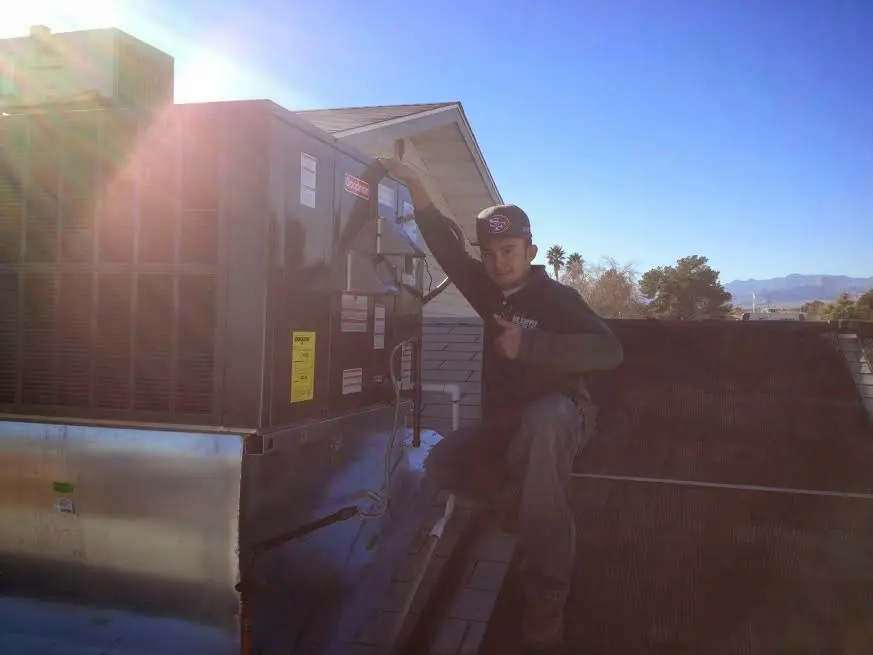 HVAC technician performing AC Tune-Up on a rooftop unit in Earlimart
